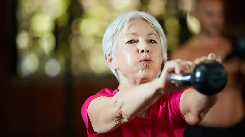 Toning Arms After 60: Empowering Womens Fitness Through Effective Weight Training 1 Older woman doing weight training Northwich to help her strength and longevity