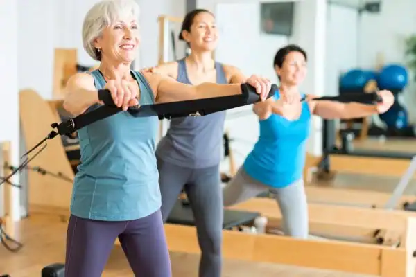 Toning Arms After 60: Empowering Womens Fitness Through Effective Weight Training 2 older woman doing weight training Northwich and resistance in the gym to tone upper arms