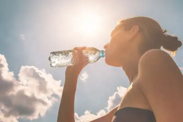 Hydration: The Secret Ingredient for a Toned Stomach and Enhanced Fitness 3 Image of woman drinking water to hydrate Northwich after run.